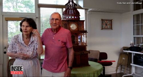 Mr LeSeige smiles with his wife by the cathedral he built.