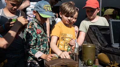 Des enfants tiennent divers engins explosifs lors d'une leçon publique sur la sécurité dans les mines le 11 juin 2022 à Kyiv, en Ukraine.  La région autour de la capitale ukrainienne continue de se remettre de l'assaut avorté de la Russie sur Kyiv, qui a transformé de nombreuses communautés en champs de bataille. 