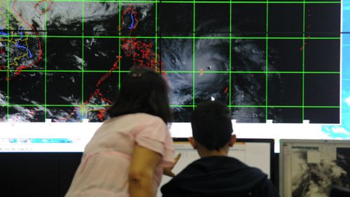 Meteorologists from the Philippine Atmospheric, Geophysical and Astronomical Services Administration (PAGASA) monitor and plot the direction of super typhoon Hagupit. (Getty Images)