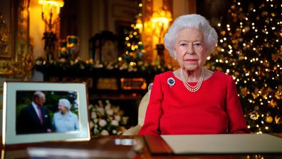 Queen Elizabeth II records her annual Christmas broadcast in the White Drawing Room at Windsor Castle on December 23, 2021 in Windsor, England. The photograph on the desk is of The Queen and the Duke of Edinburgh, taken in 2007 at Broadlands, Hampshire, to mark their Diamond Wedding Anniversary. 