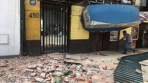 A man enters a damaged building after an earthquake in Mexico City. (AAP)