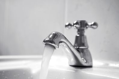 Close up of chrome tap, water running.