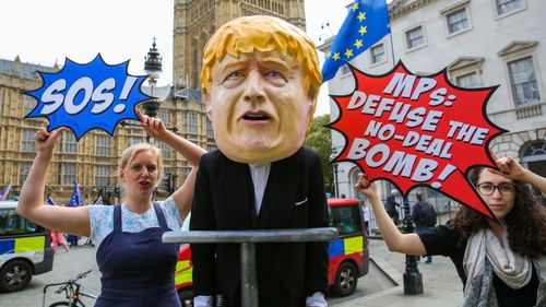 A man is seen dressed as British Prime Minister Boris Johnson pushing the plunger on a 'No-Deal Bomb' while demonstrating in central London.