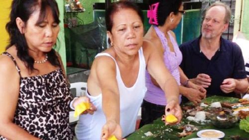 Paddock (far right) shares a meal with Marilou Danley's family in the Philippines.