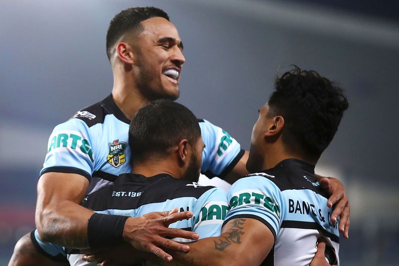 Valentine Holmes and Ricky Leutele of the Sharks celebrate with Sosaia Feki after he scored a try in the 2018 qualifying final against the Roosters.