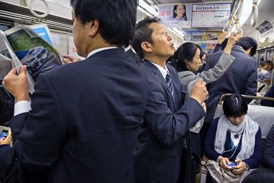 A moment of thoughts on the way to the office, in the Tokyo subway (Japan, 2015).