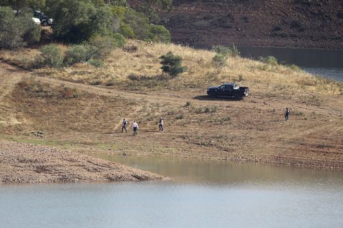 A police search team walk on the shore of the Arade dam near Silves, Portugal, Wednesday May 24, 2023.  