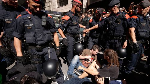 Catalan regional police officers 'Mossos D'Esquadra' try to disperse protesters in front of the headquarters of Catalonia's foreign affairs ministry in Barcelona. (AFP)