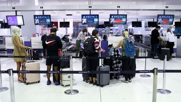 Travelers queue to check in at the departure hall of the international terminal of Sydney Airport 