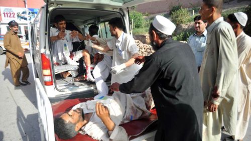 Pakistani paramedics help injured blast victims as they arrive at a hospital in Peshawar. (Getty)