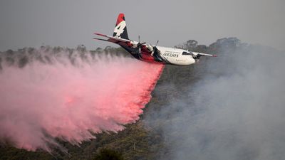 The NSW Rural Fire Service Large Air Tanker (LAT) drops fire retardant on the Morton Fire burning in bushland close to homes at Penrose in the NSW Southern Highlands, 165km south of Sydney, Friday, January 10, 2020