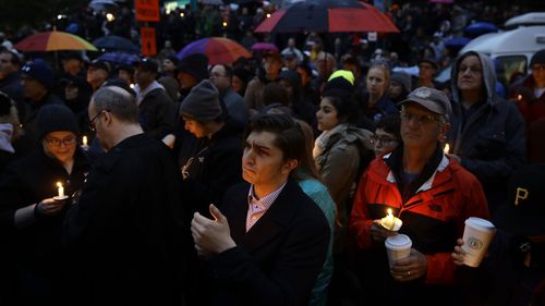 People hold candles as they gather for a vigil in the aftermath of a deadly shooting at the Tree of Life Synagogue