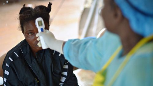 A girls suspected of being infected with the Ebola virus has her temperature checked at the hospital in Kenema, Sierra Leone. (Getty Images)