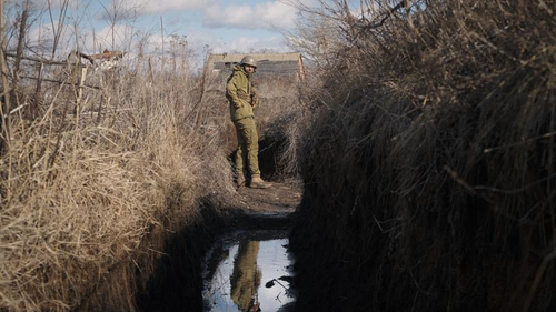 A Ukrainian serviceman pauses while walking to a frontline position outside Popasna, in the Luhansk region of eastern Ukraine. 