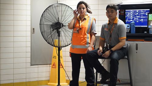 Train station staff stay in front of a fan. Photo: Dion Georgopoulos / The Sydney Morning Herald