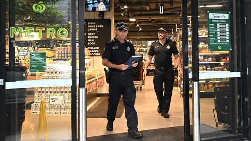 Police are seen at the Woolworths Metro store after the vandalism was discovered.