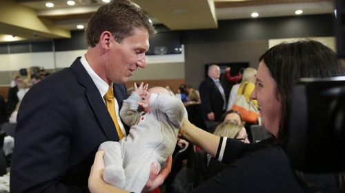 Senator Bernardi holds a baby before the debate begins. (AAP)