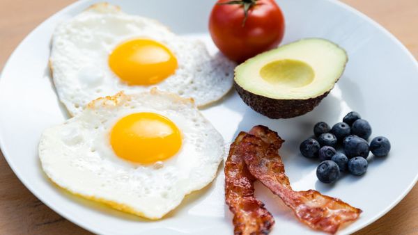 High fat low-carb breakfast with eggs, tomato, avocado, bacon and blueberries. iStock
