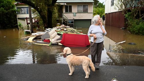 Local resident Cathy Jordan inspects floodwater in her street in Lismore.