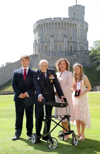 Captain Sir Thomas Moore poses with his family after being awarded with the insignia of Knight Bachelor by Queen Elizabeth II at Windsor Castle on July 17, 2020 in Windsor, England.