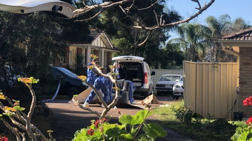 Police removing an armchair as evidence from the scene.