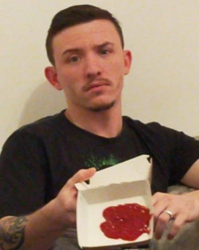 Disappointed man holds up box of ketchup