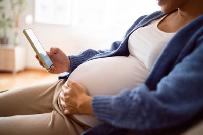 A pregnant woman using her phone