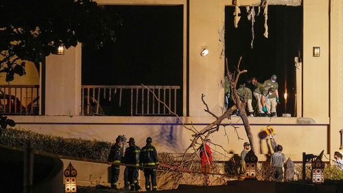Firemen and rescue workers inspect the site of an explosion at the Fairmont The Palm Hotel in Dubai, United Arab Emirates, Saturday, Feb. 28, 2026. (AP Photo/Altaf Qadri)