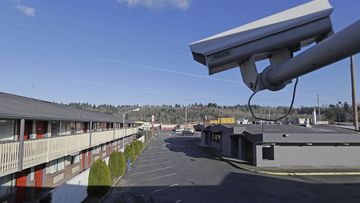 In this March 4, 2020 file photo, a security camera is shown on the second floor of a row of rooms at a motel in Kent, Wash. Hackers aiming to call attention to the dangers of mass surveillance said they were able to peer into hospitals, schools, factories, jails and corporate offices after they broke into the systems of a security-camera startup