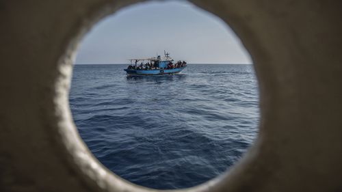 A migrants boat is seen though a porthole before being rescued by the Open Arms aid boat on Sunday June 30, 2019