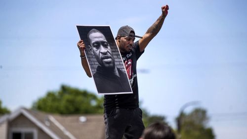 Tony L. Clark holds a photo of George Floyd on Thursday in Minneapolis.