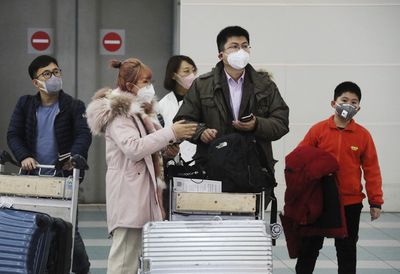 Passengers from China wear face masks