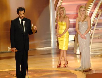 BEVERLY HILLS, CA - JANUARY 15:  In this handout photo provided by the Hollywood Foreign Press Association, actor Sacha Baron Cohen accepts the award for Best Performance By An Actor in a Motion Picture Musical or Comedy for "Borat: Cultural Learnings of America for Make Benefit Glorious Nation of Kazakhstan" while actors Reese Witherspoon (L) and Lorraine Nicholson look on onstage during the 64th Annual Golden Globe Awards at the Beverly Hilton on January 15, 2007 in Beverly Hills, California. 