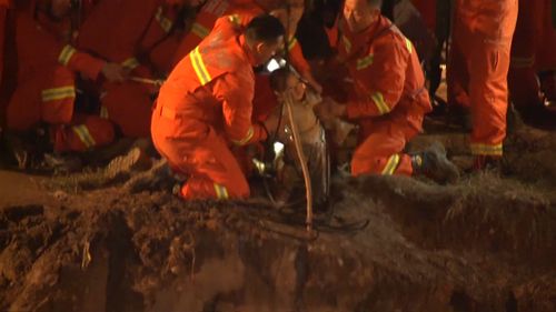 Rescuers pull the boy to safety after about 10 hours. (Reuters)