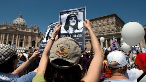 In this May 27, 2012, file photo, demonstrators hold pictures of Emanuela Orlandi reading "march for truth and justice for Emanuela" during Pope Benedict XVI's Regina Coeli prayer in St. Peter's square, at the Vatican.