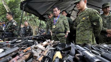 Rodrigo Duterte looks at weapons seized by Islamist extremists in Marawi. (AAP)