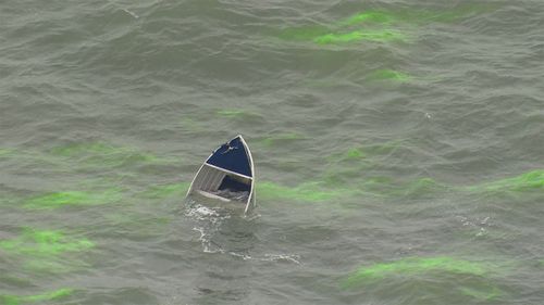 The capsized dinghy off the coast of Bronte Beach.