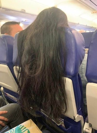 Traveller drapes hair over passenger's seat tray