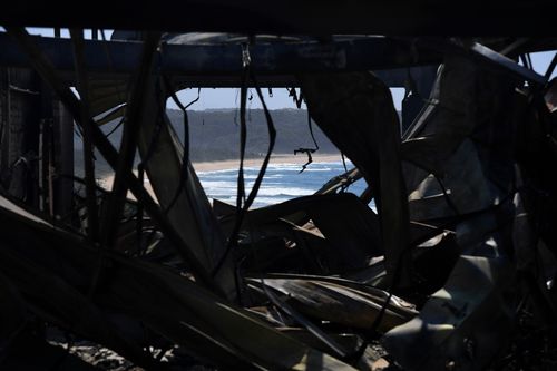 RFS and NSW Fire and Rescue continue to mop up and douse smouldering homes after a devastating fire ripped through the town. (AAP)