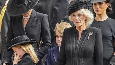 Kate, Princess of Wales, from left, Princess Charlotte, wiping her eye, Prince George, Camilla, the Queen Consort and Meghan, Duchess of Sussex follow the coffin of Queen Elizabeth II following her funeral service in Westminster Abbey in central London Monday Sept. 19, 2022. The Queen, who died aged 96 on Sept. 8, will be buried at Windsor alongside her late husband, Prince Philip, who died last year. (AP Photo/Martin Meissner, Pool)