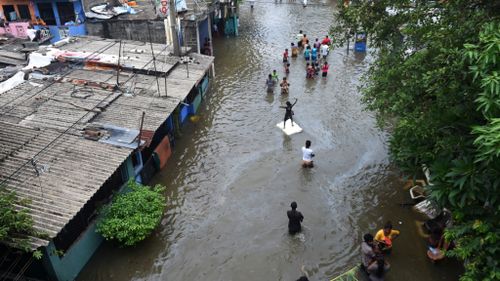 Colombo residents wade through floodwaters. (AFP)