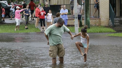 Residents make their way across a flooded street after Hurricane Irma brought floodwaters to Jacksonville. (AAP)