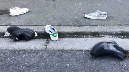 Stray shoes litter the gutter outside the Dunedin home where a student was crushed to death.