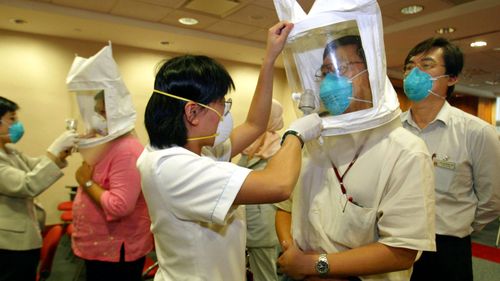 In this 2003 photo, employees at the Tan Tock Seng hospital are fitted for masks that offer protection against the Severe Acute Respiratory Syndrome (SARS) virus in Singapore.