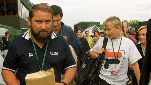 Australia's Jelena Dokic walks through Wimbledon with her father, Damir, on June 22, 1999, after defeating Martina Hingis in their Women's Singles, first round match. (AAP)