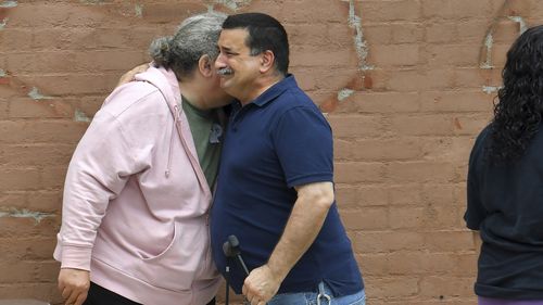 A unidentified man, right, appears emotional while embracing a resident of the Gabriel House assisted living facility, left, in Fall River, Mass., outside a temporary shelter, Monday, July 14, 2025, in Fall River, following a fire at the Gabriel House that started late Sunday and resulted in multiple fatalities. (AP Photo/Steven Senne)
