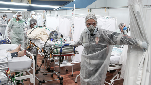 Des membres du personnel médical transportent un patient sur une civière à l'hôpital de campagne du complexe sportif Pedro DellAntonia alors que les cas de coronavirus montent en flèche le 11 mars, à Santo Andre, au Brésil.  (Alexandre Schneider / Getty Images Amérique du Sud / Getty Images)