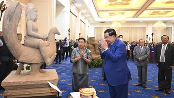 Cambodian Prime Minister Hun Sen, centre right, prays together with his minister of Culture and Fine Arts Phoeung Sackona, centre left, in front of a sandstone statue at Peace Palace, in Phnom Penh, Cambodia, Friday, March 17, 2023. 
