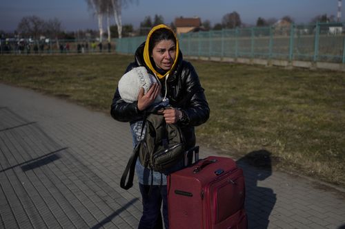 Ukrainian family members meet at the Medyka border crossing, in Medyka, Poland, Saturday, Feb. 26, 2022. The U.N. refugee agency said Saturday that nearly 120,000 people have so far fled into neighboring countries and that number is going up fast. (AP Photo/Bernat Armangue) (AP Photo/Bernat Armangue)