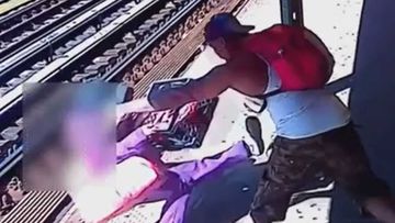The CCTV shows a man throwing a woman onto the tracks.